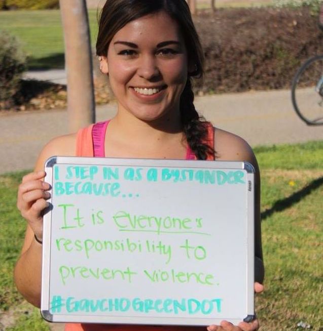 Student holding a sight that says "I step in as a bystander because...it is everyone's responsibility to prevent violence. #GauchoGreendot"
