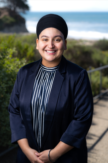 Harleen Kaur Jassal Headshot standing in front of greenery and the ocean 