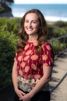 Jamie File Headshot standing in front of greenery and the ocean